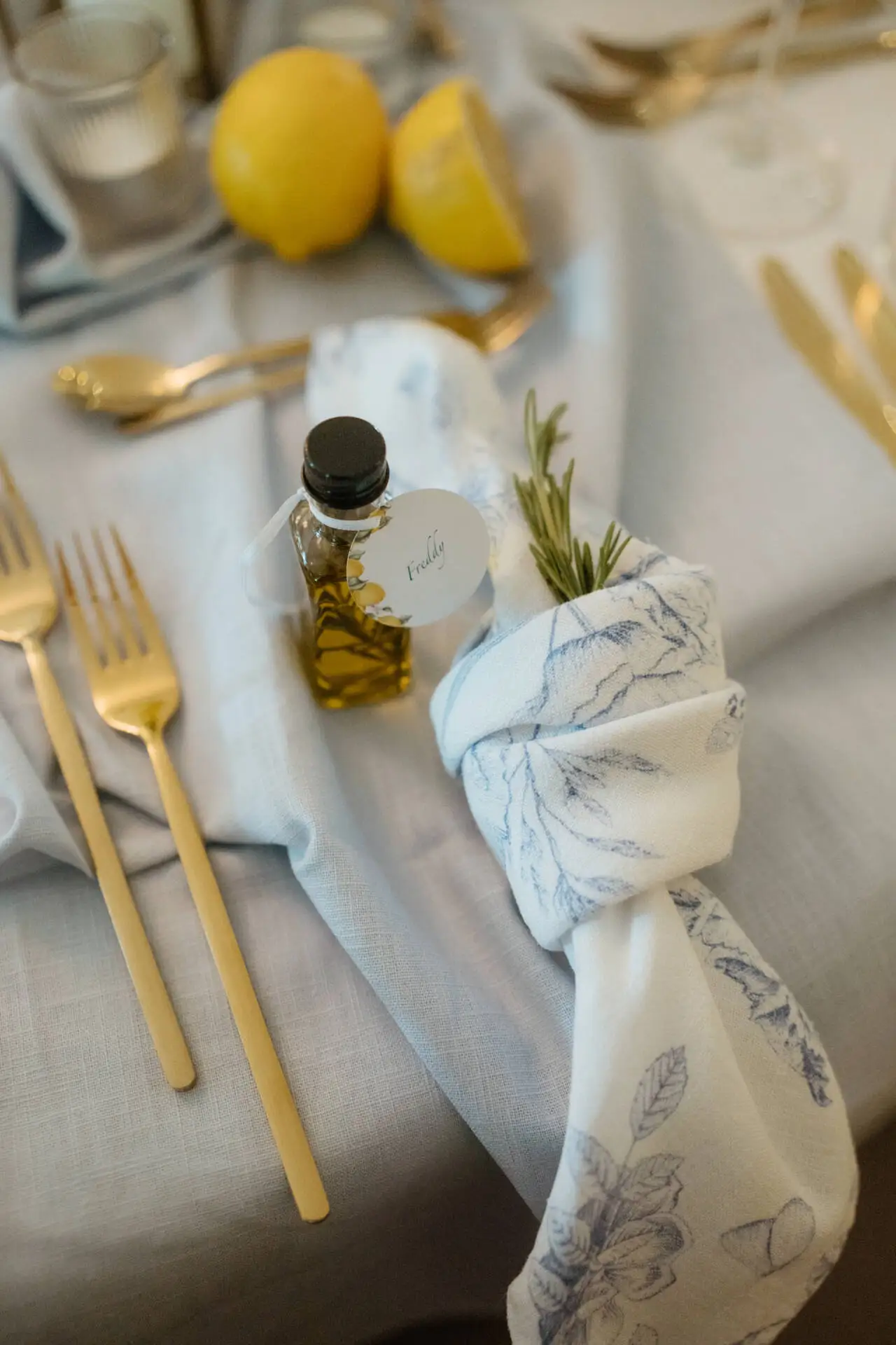 Elegantes Gedeck mit Öl, Zitrone, Besteck, Serviette.