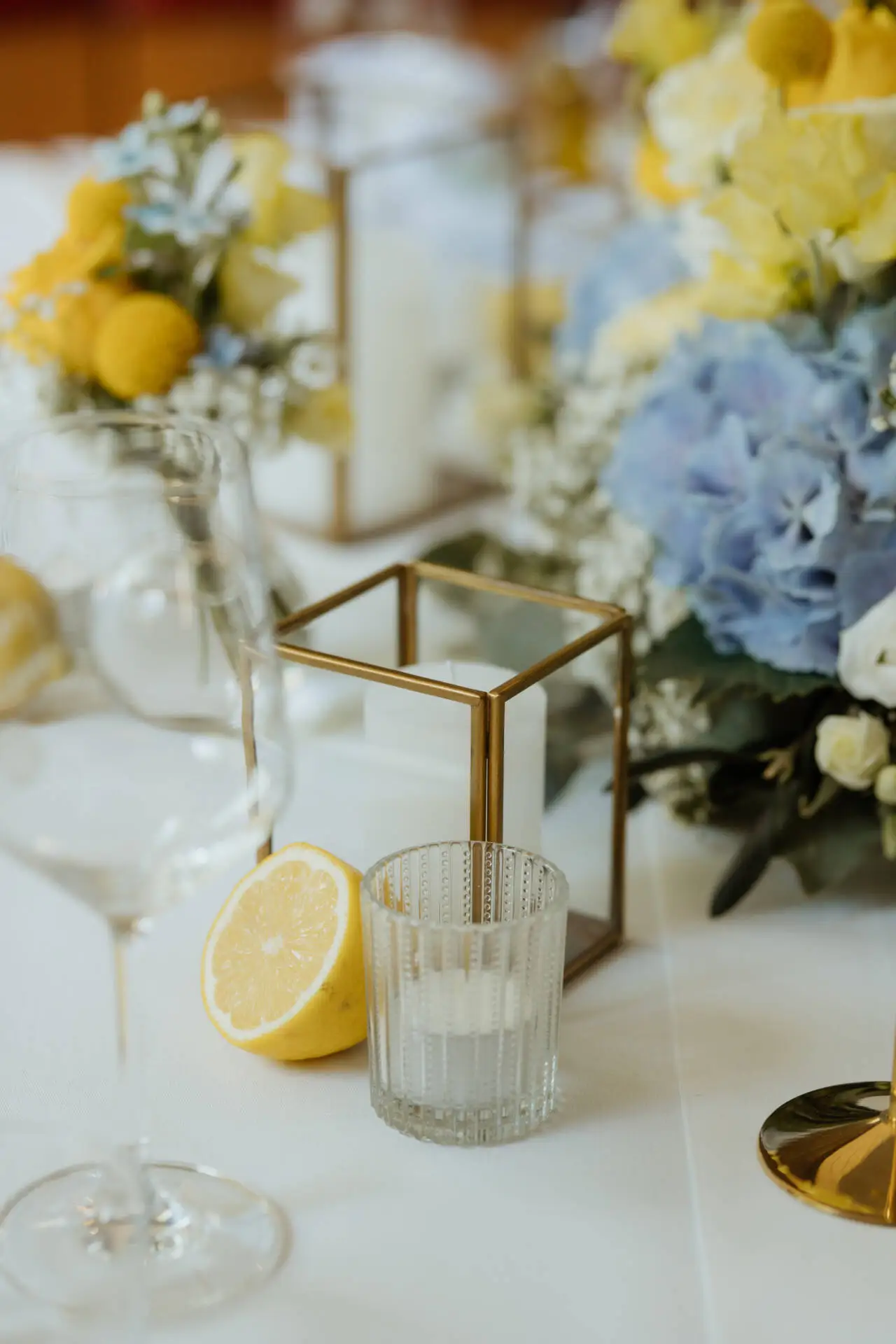 Tischdeko mit Kerzen, Blumen und Zitrone