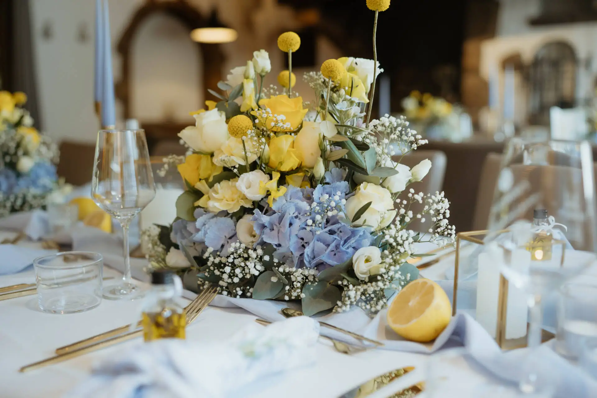 Blumengesteck auf einem festlich gedeckten Tisch.