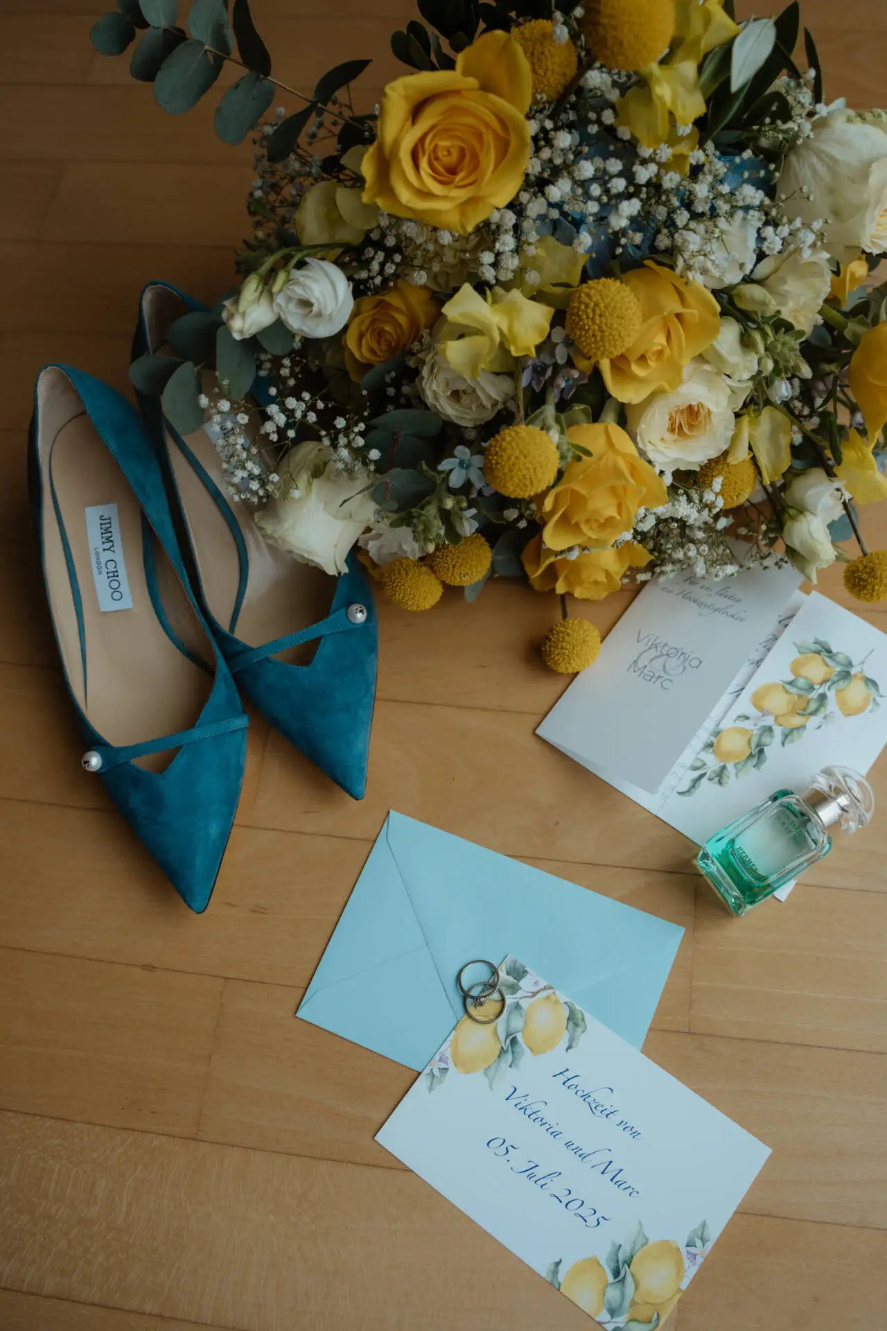 Blumen, Schuhe und Hochzeitseinladung auf Holz.