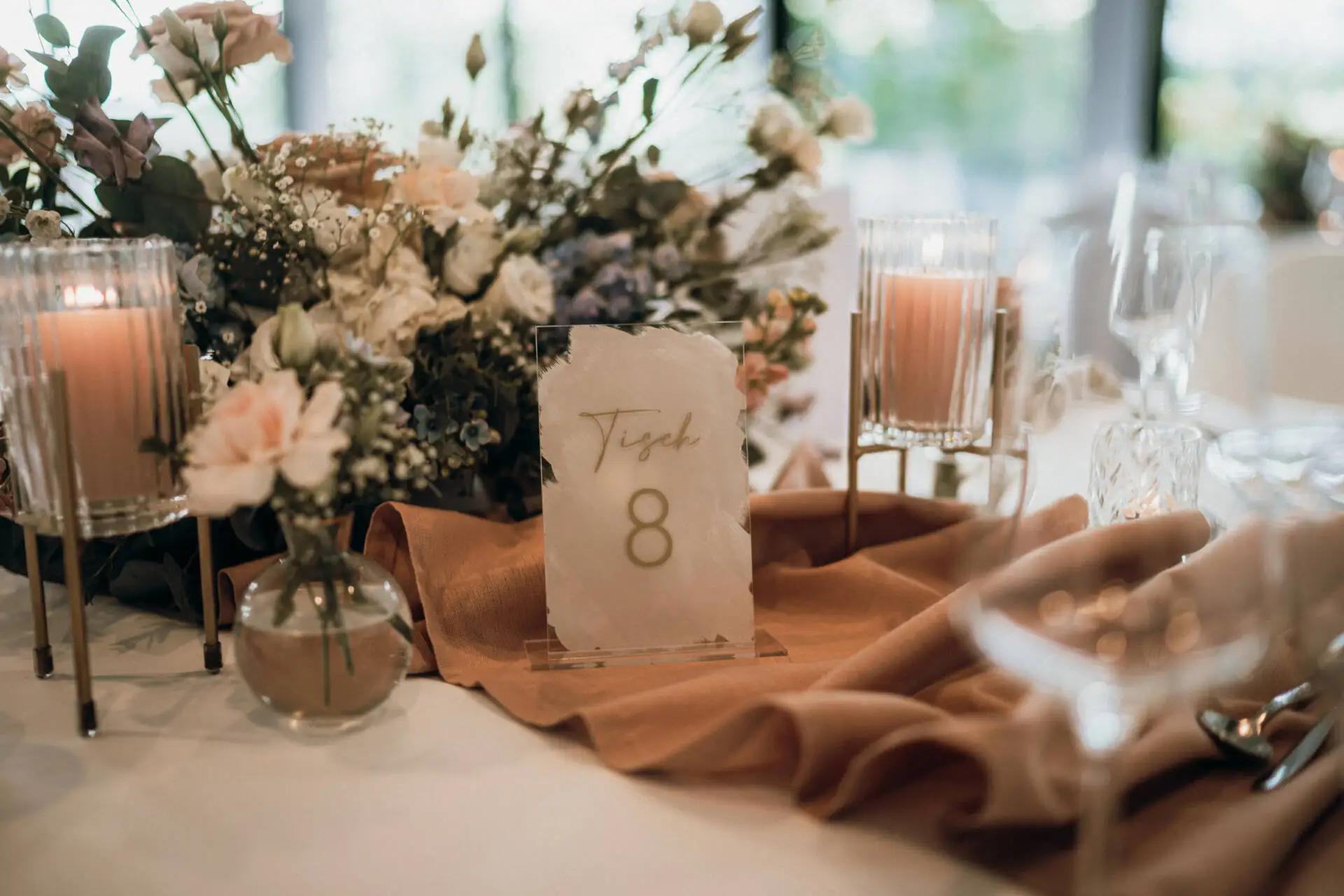 Elegante Tischdekoration mit Blumen und Kerzen.