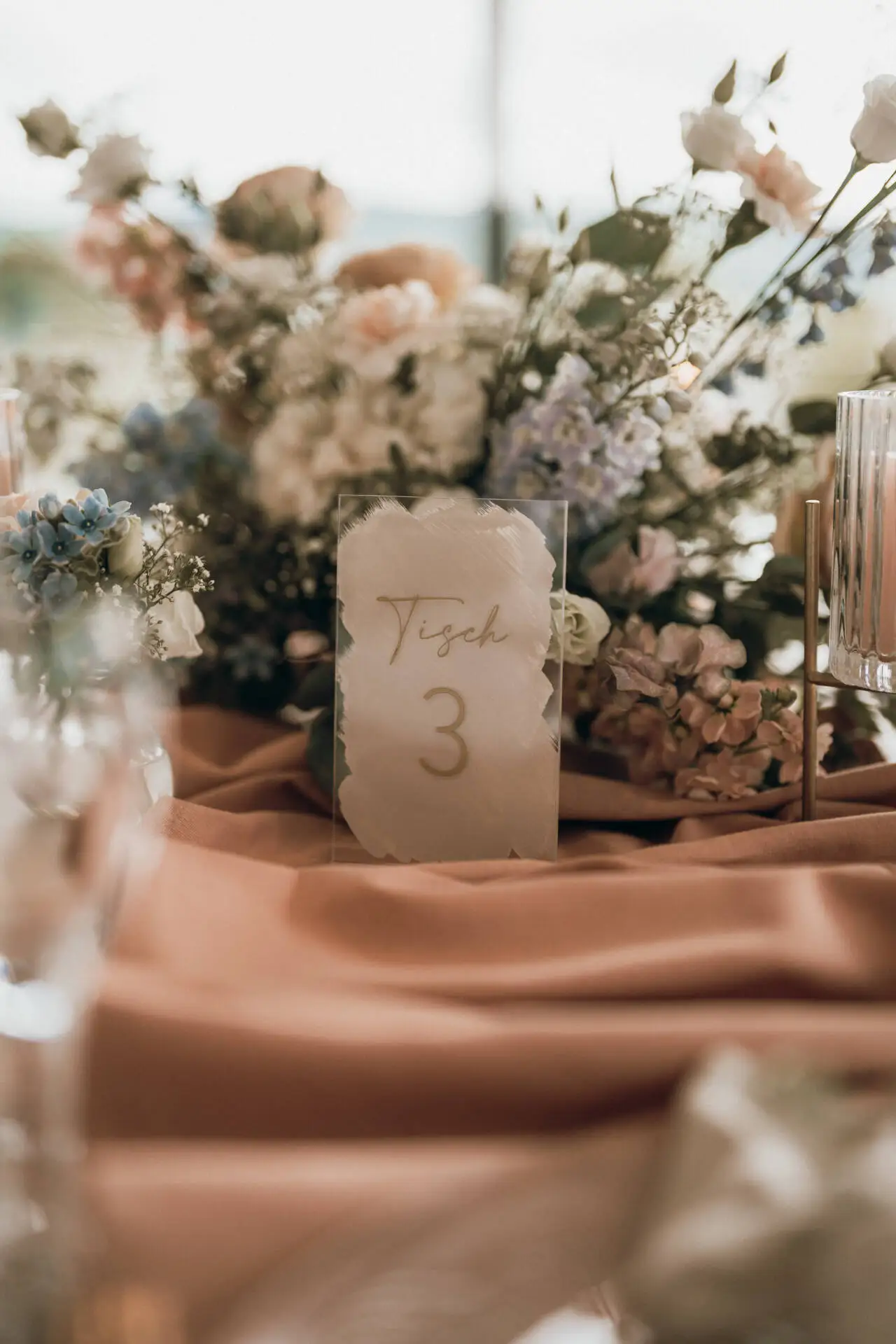 Tischkarte Nummer drei mit Blumenarrangement