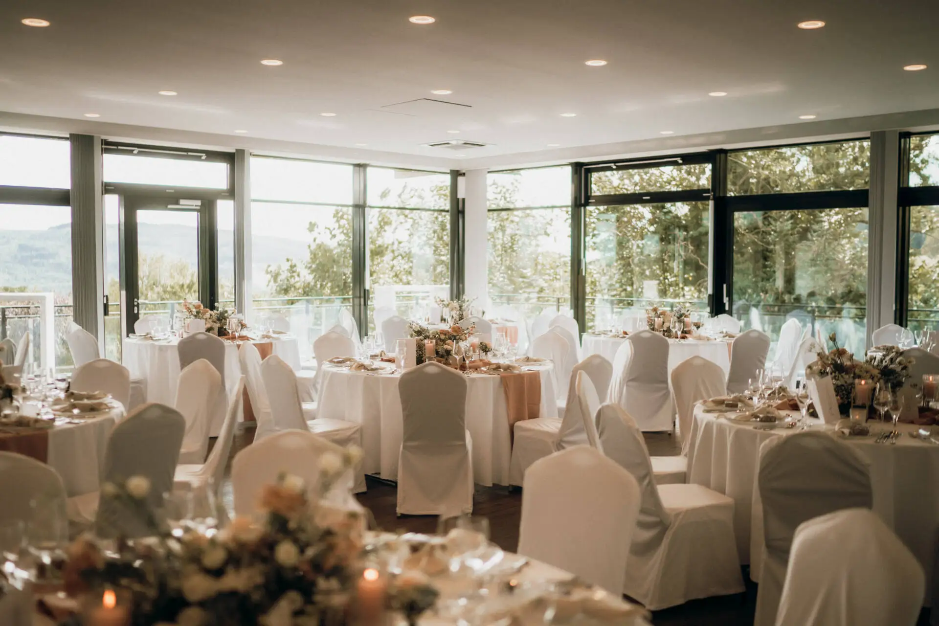 Eleganter Hochzeitssaal mit gedeckten Tischen