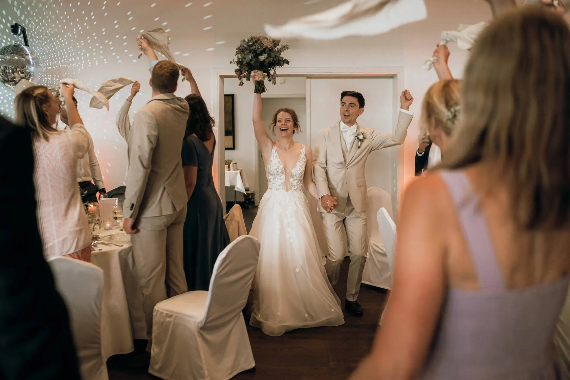 Brautpaar betritt den festlichen Saal mit Gästen.