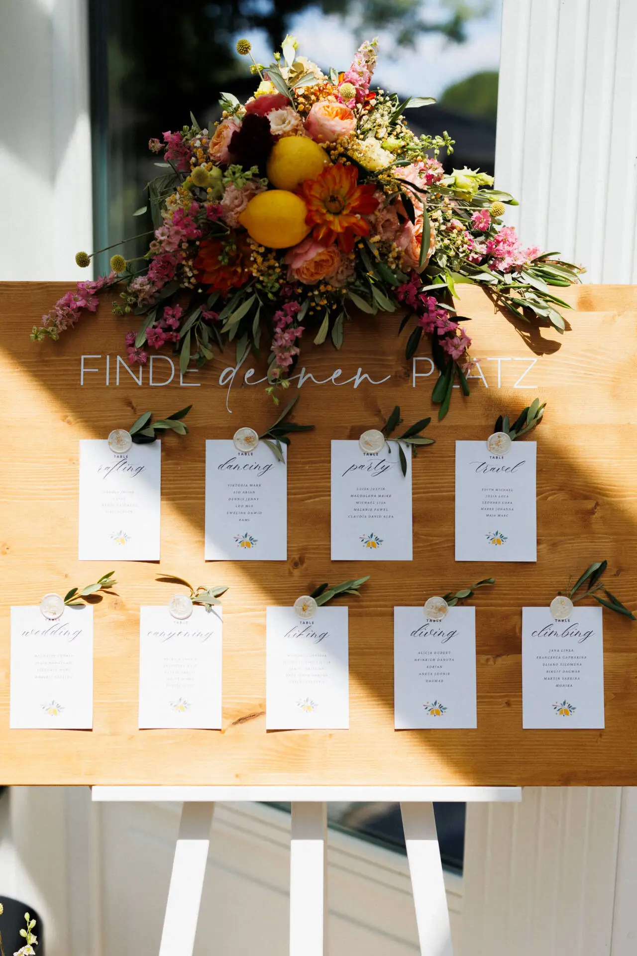 Hölzernes Sitzplan-Schild mit Blumen dekoriert.