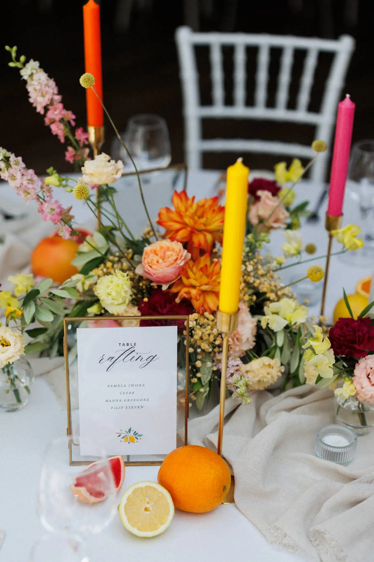 Farbenfrohe Tischdekoration mit Blumen und Früchten.