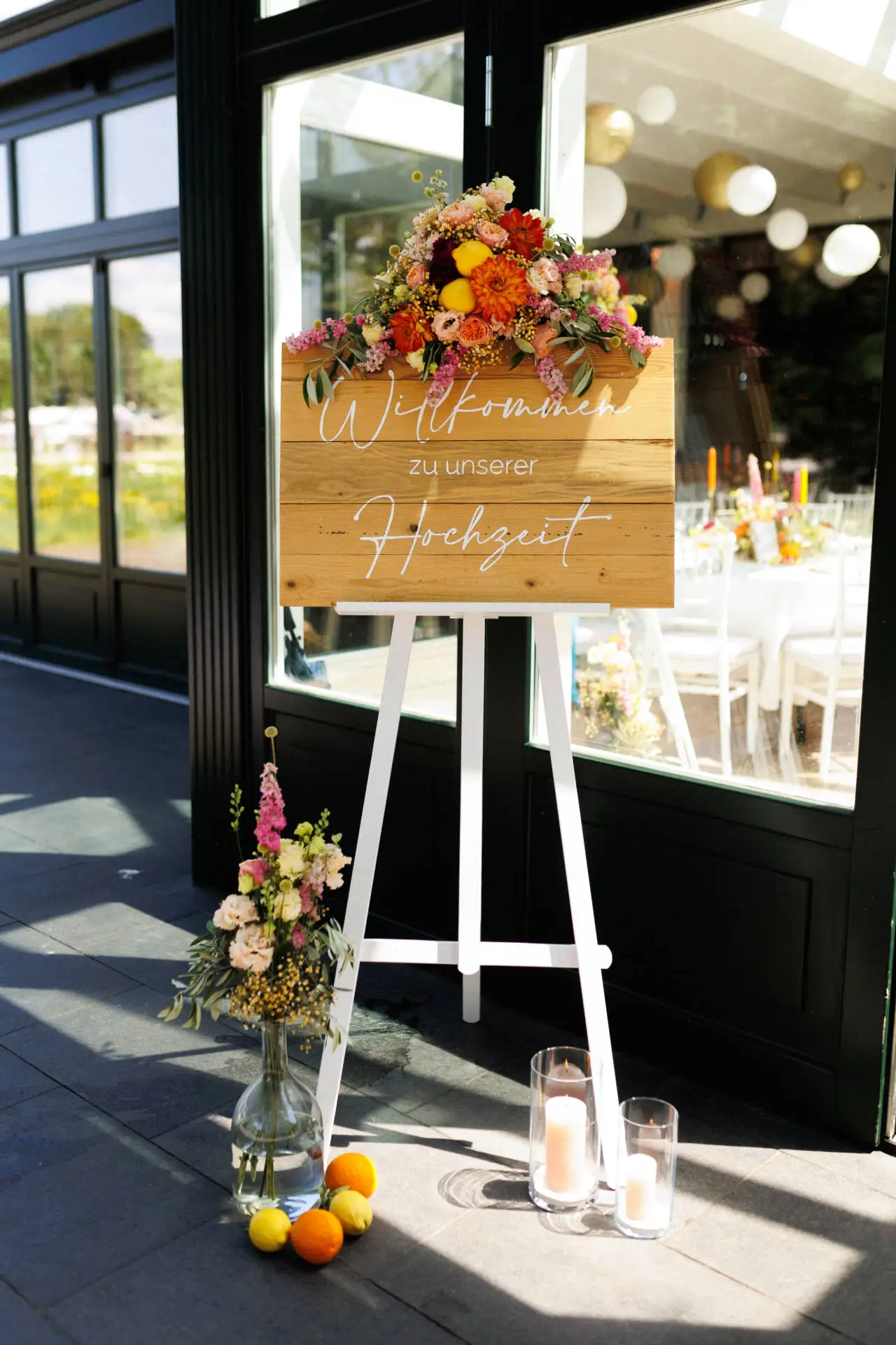 Hochzeits-Willkommensschild mit Blumen und Kerzen