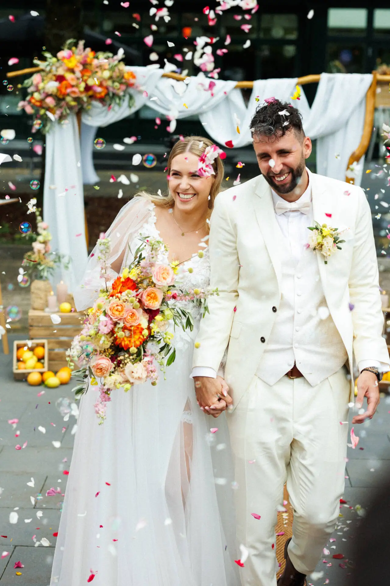 Lächelndes Brautpaar unter Konfettiregen