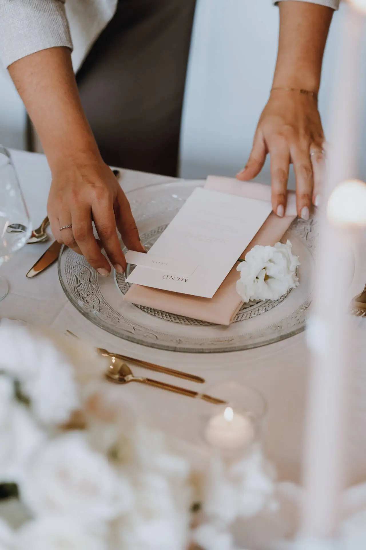 Tischdeko mit Menü und Blume.