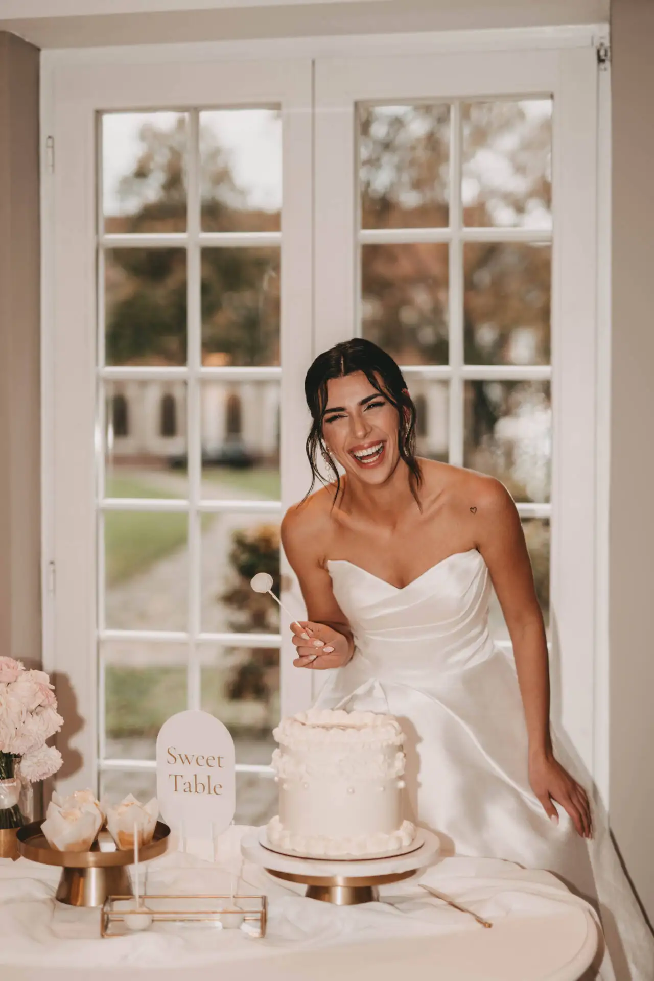 Frau im weißen Kleid neben Hochzeitstorte