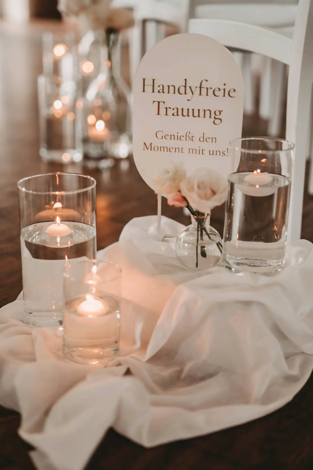 Kerzen und handgeschriebene Hochzeitseinladung mit Blumen