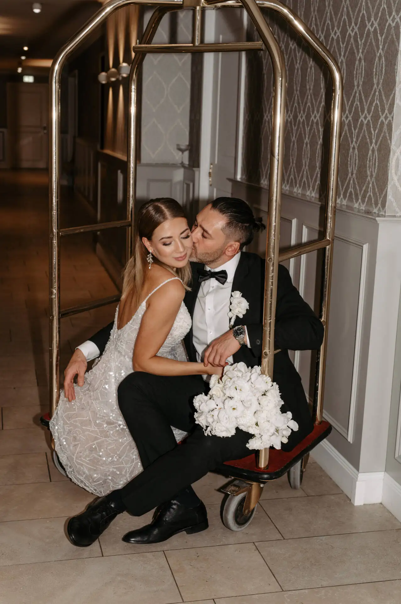 Brautpaar auf Gepäckwagen mit Blumenstrauß