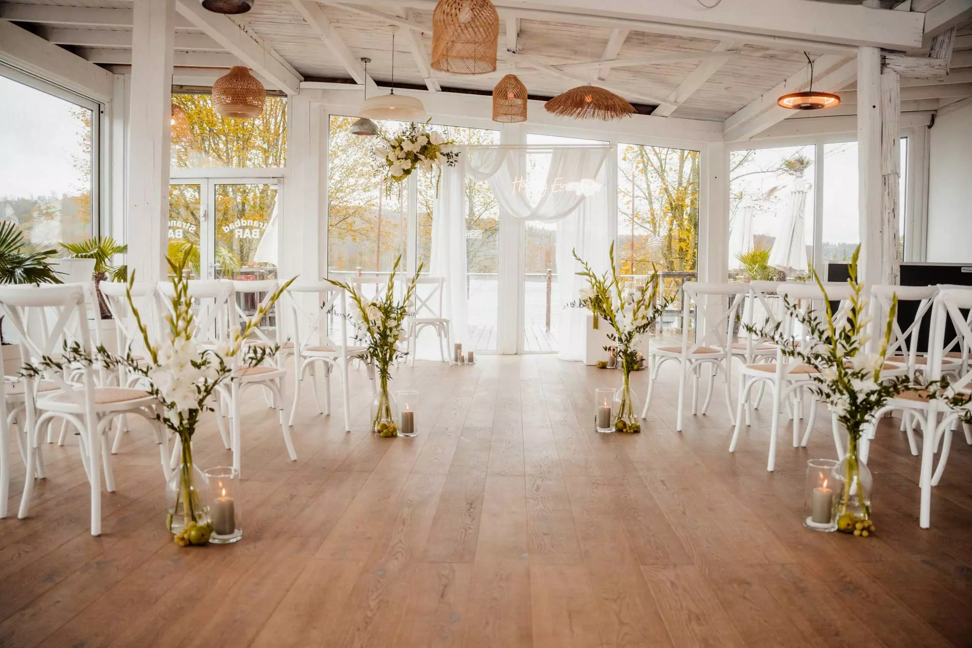 Hochzeitsdekoration mit Blumen und Kerzen im Raum.