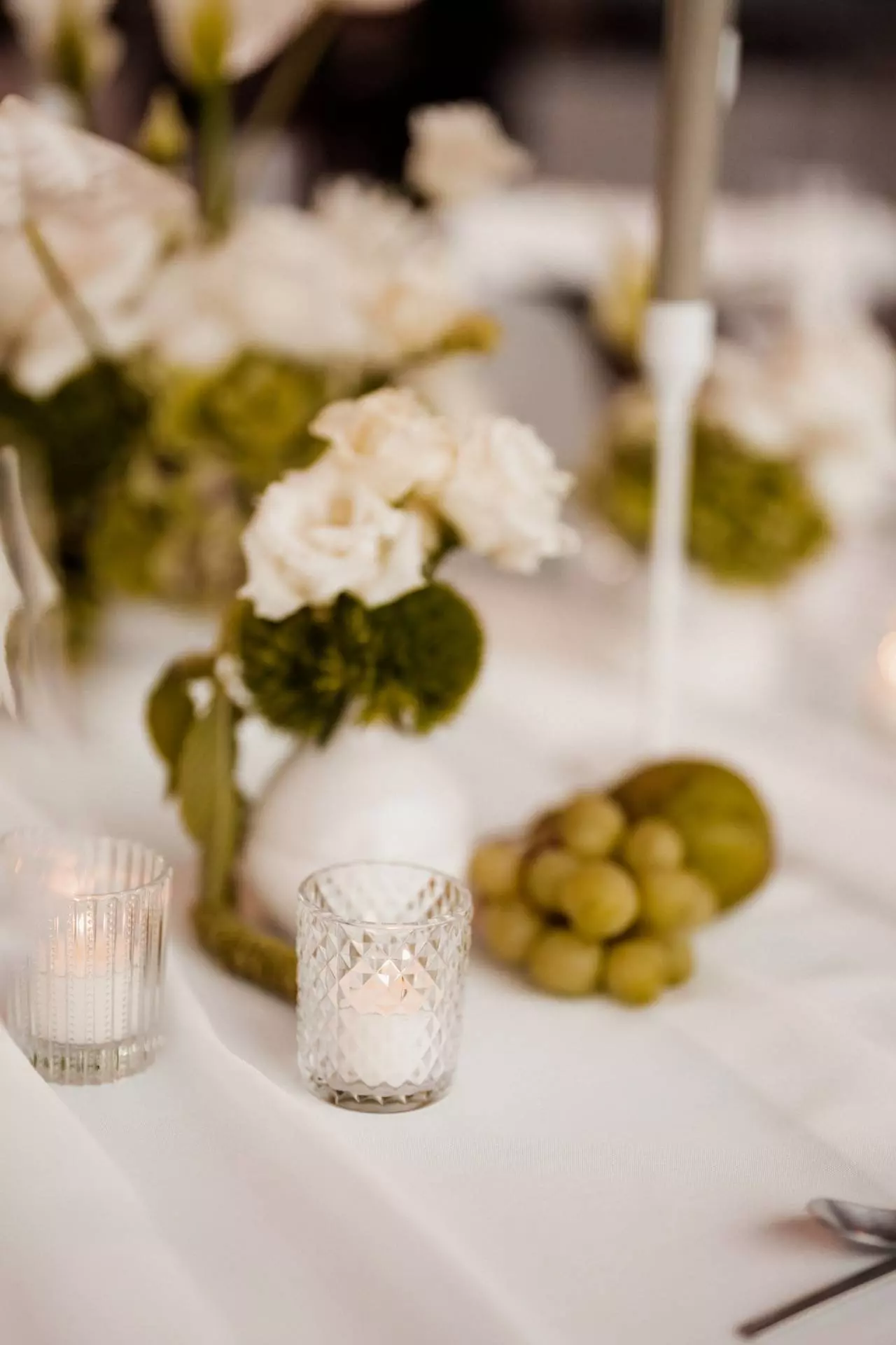 Hochzeitsdeko mit Blumen und Kerzen auf Tisch