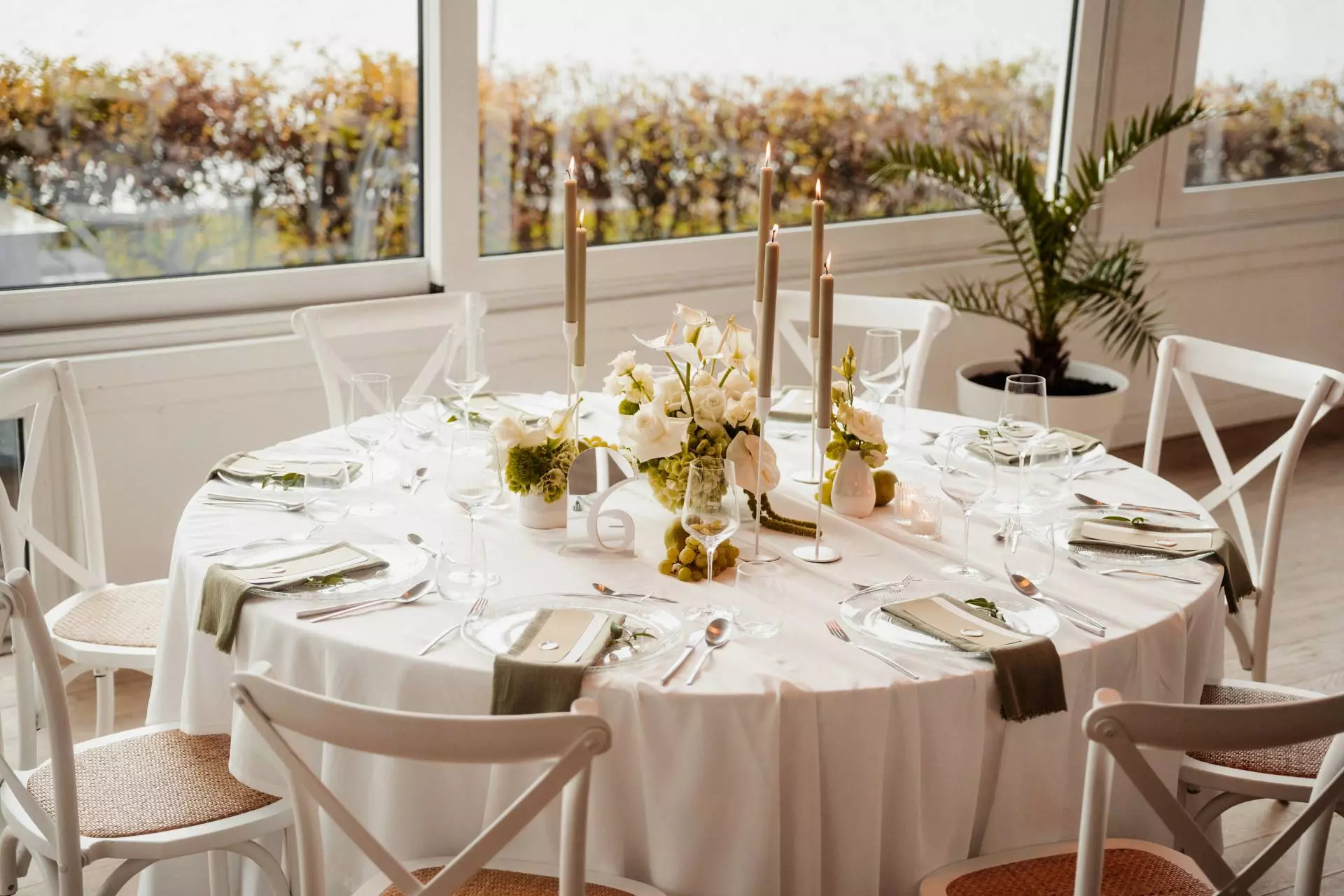 Elegant gedeckter Tisch mit Kerzen und Blumen.