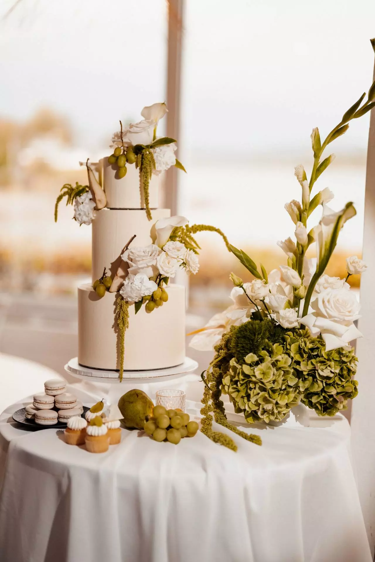 Dreistöckige Hochzeitstorte mit weißen Blumen dekoriert.