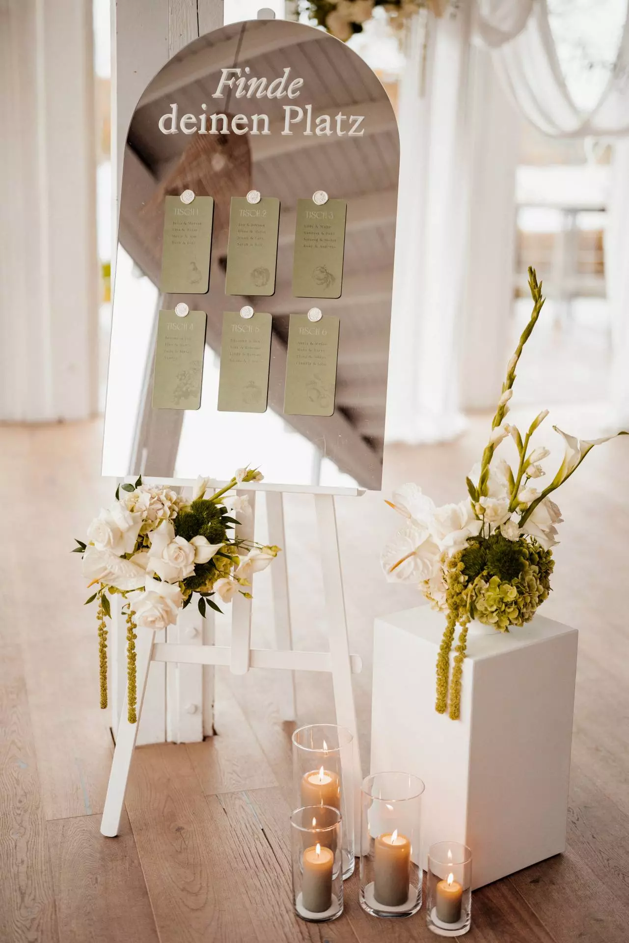 Tafel mit Tischplankarten und Blumendekoration.
