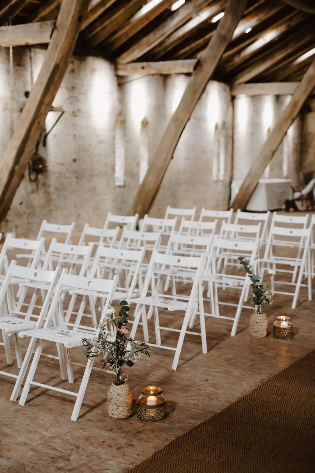 Leere Hochzeitsstühle in rustikalem Dachbodenambiente.
