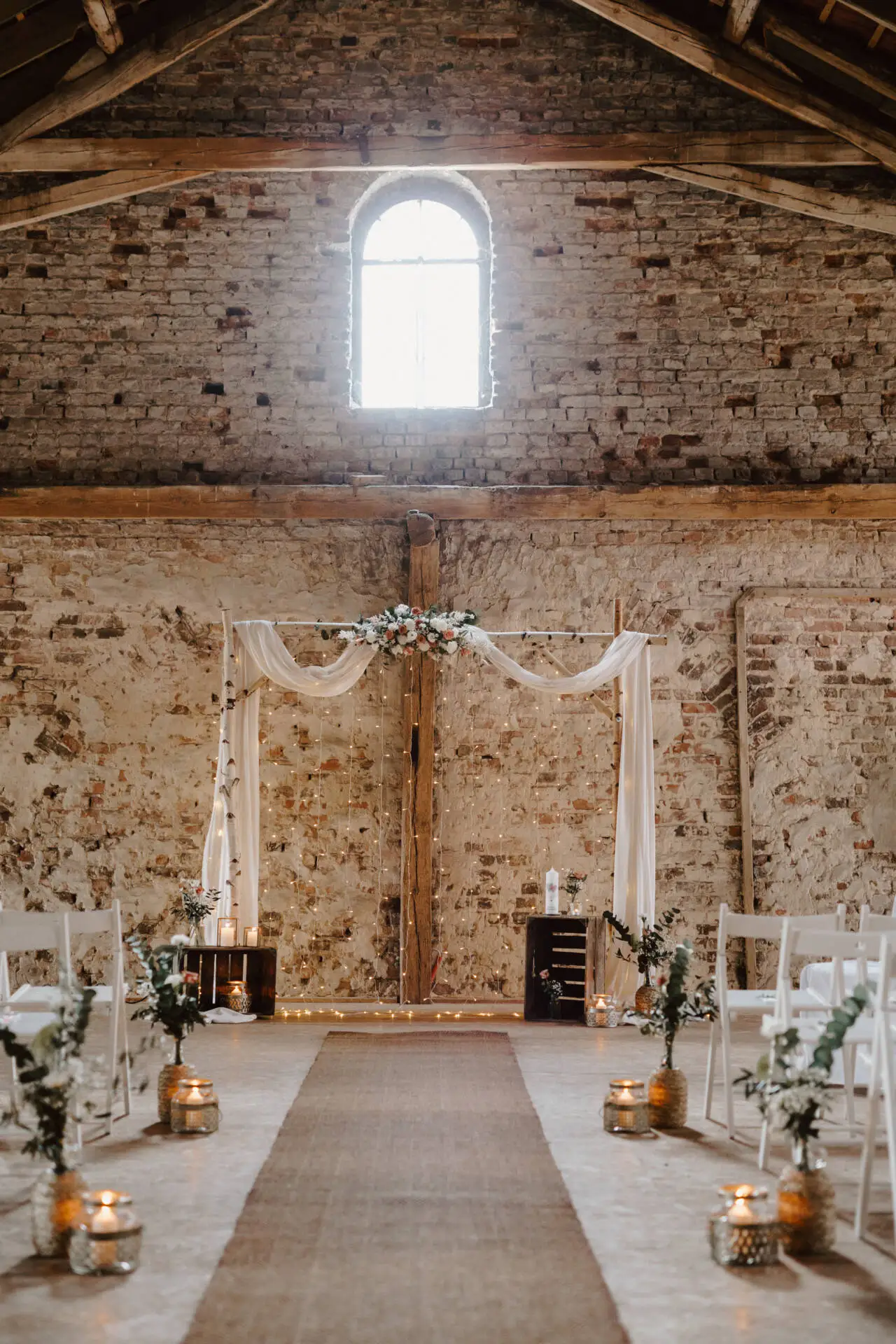 Rustikale Hochzeitsdekoration in einer Scheune mit Blumen.
