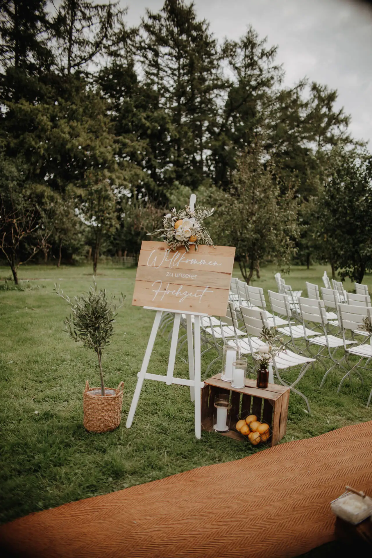 Hochzeitsdekoration im Freien mit Willkommensschild.