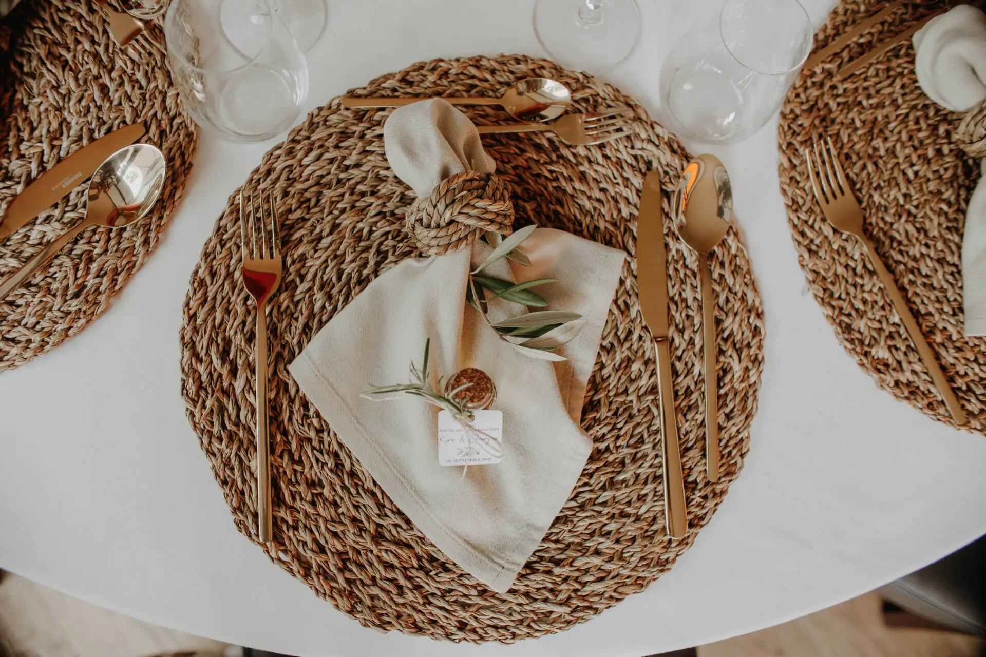 Gedeckter Tisch mit goldfarbenem Besteck und Serviette.