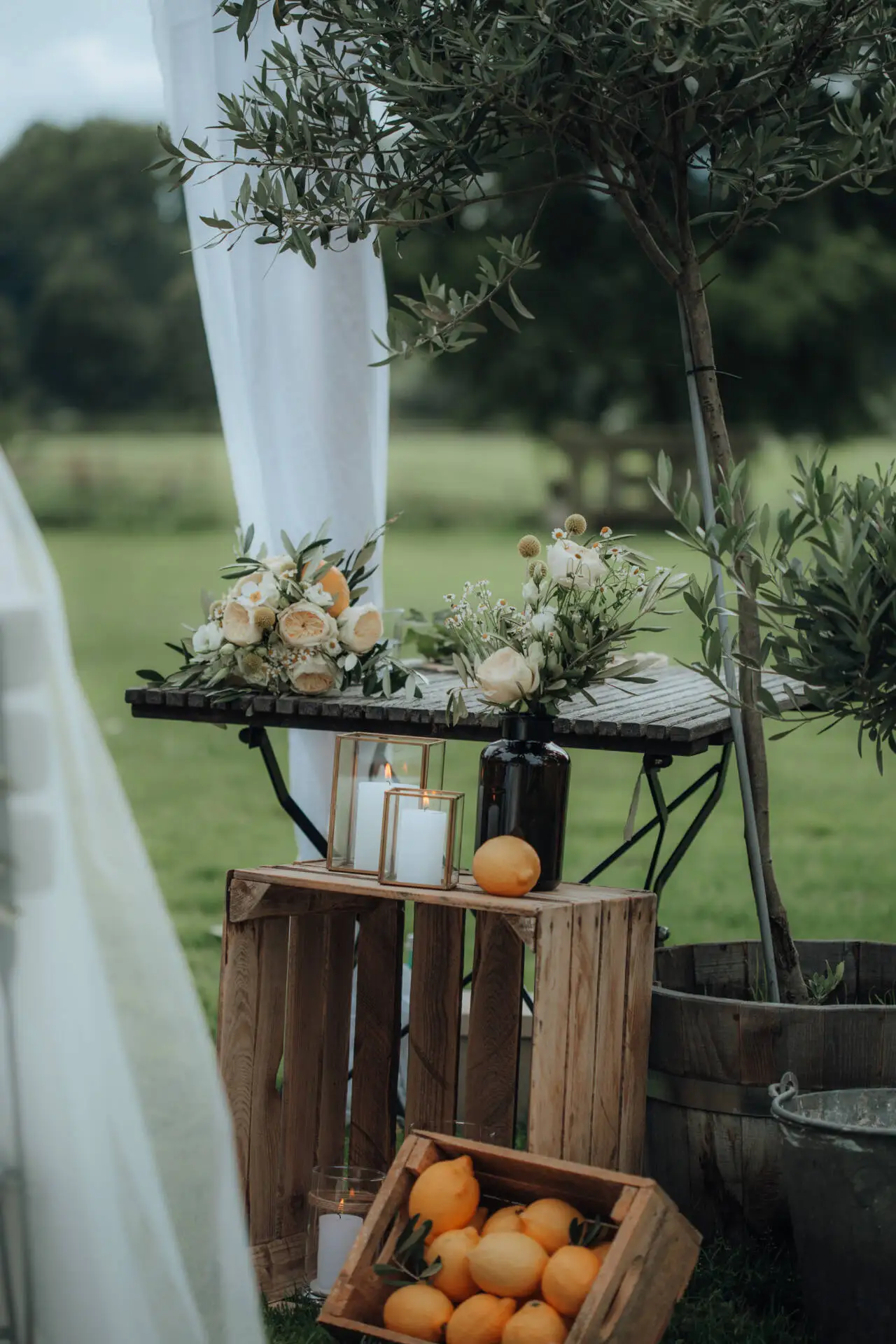 Blumendekor mit Kerzen und Zitronen im Freien.