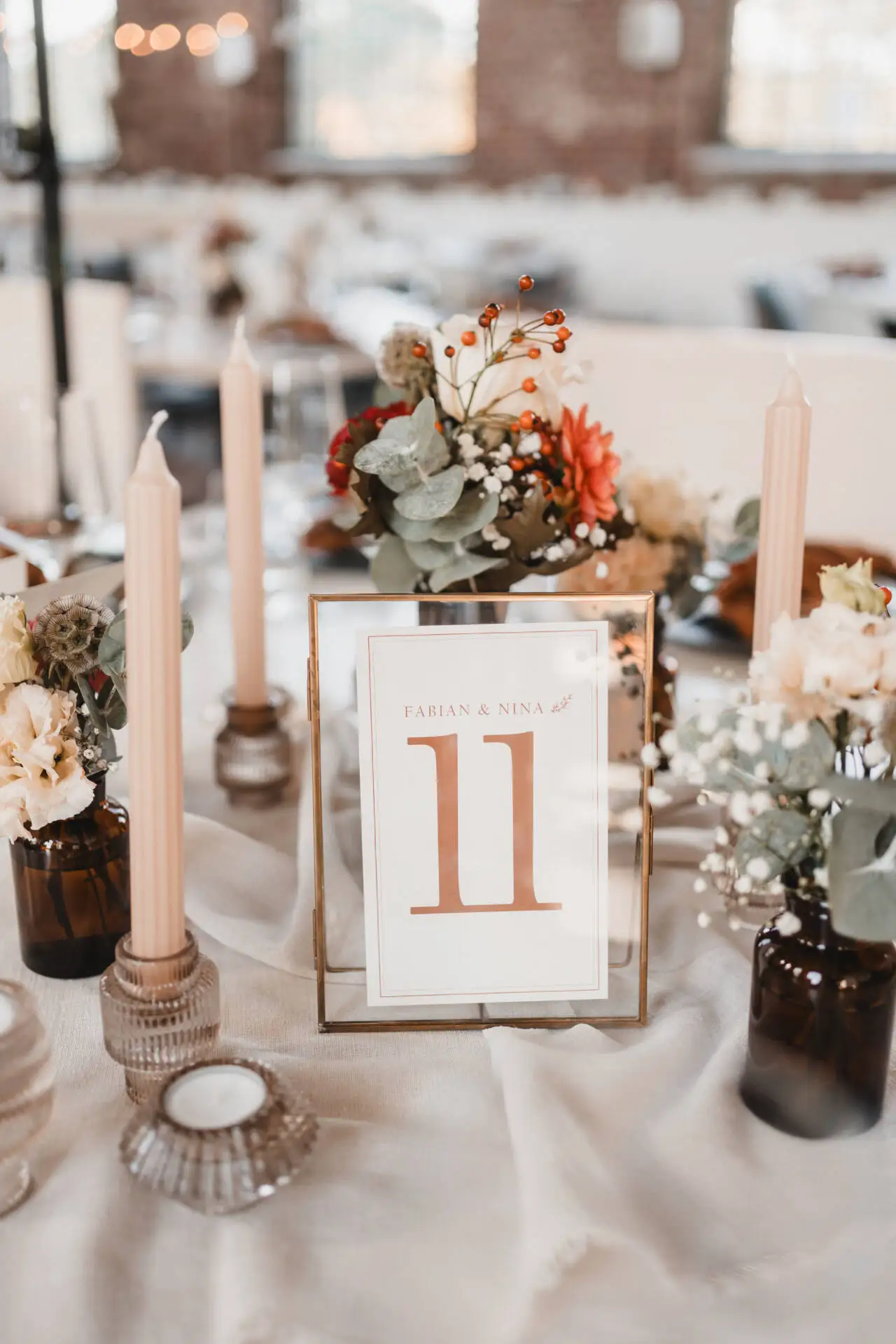 Tischdekoration mit Blumen und Tischnummer Elf