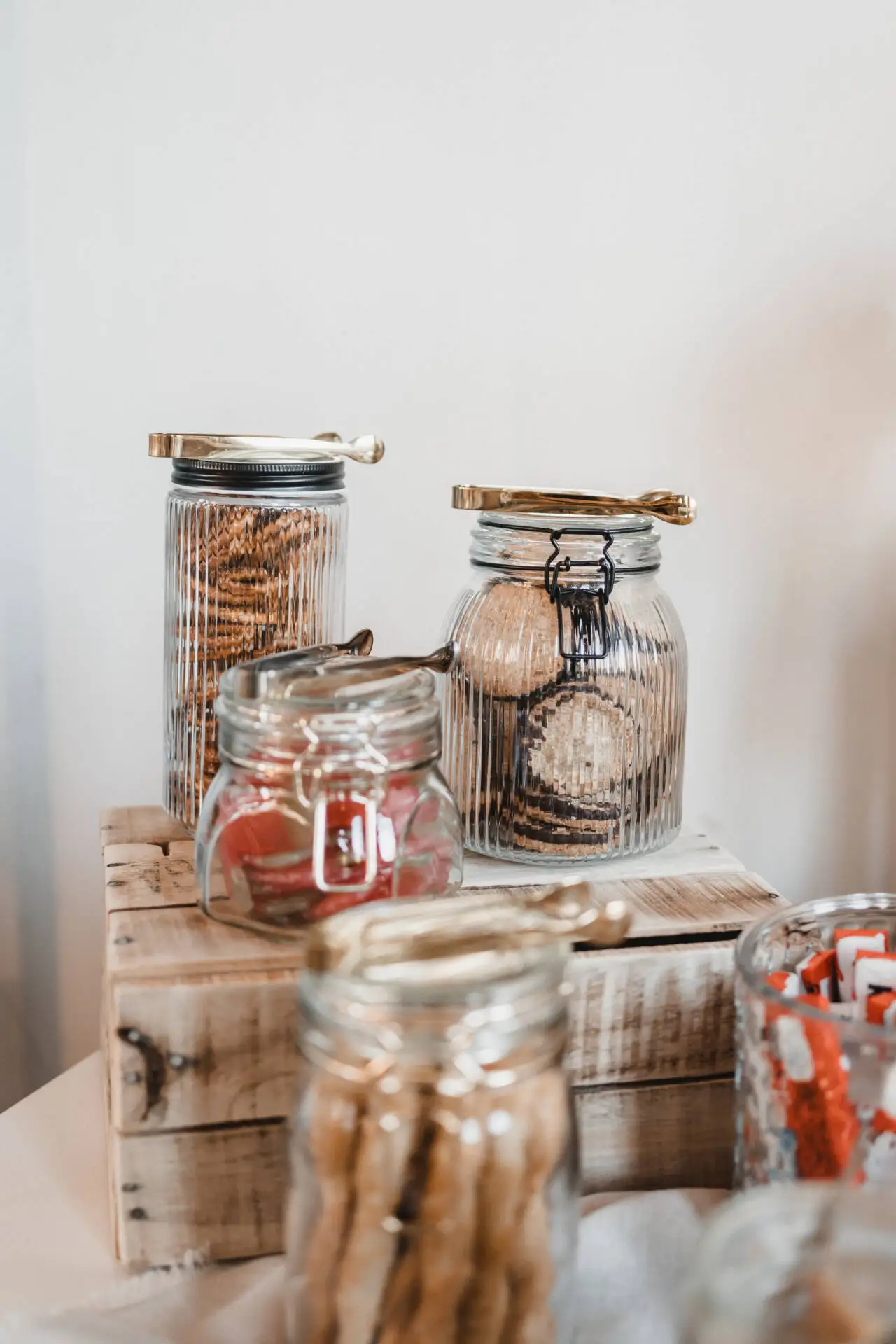 Gefüllte Gläser mit Keksen auf Holzkiste