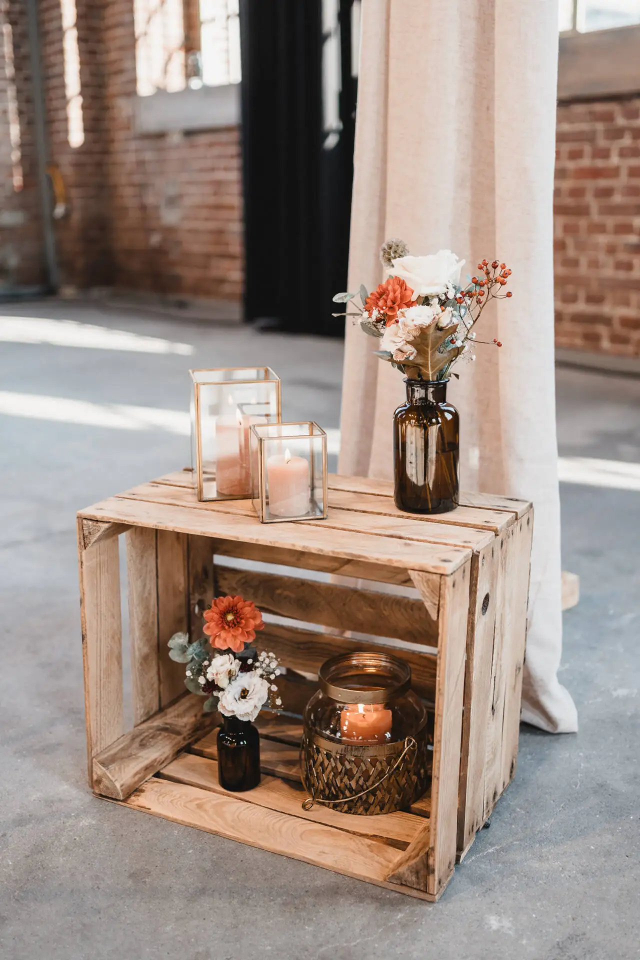 Dekorativer Holzkasten mit Kerzen und Blumen