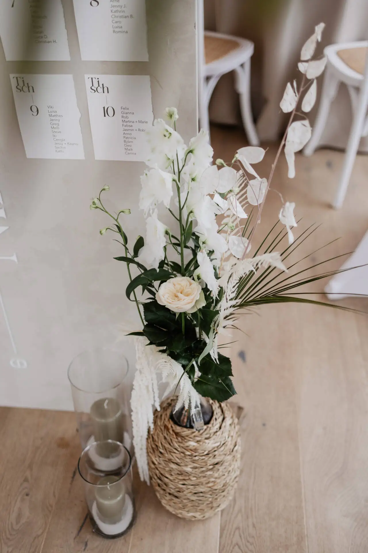Hochzeitsdeko mit Blumen und Kerzen im Glas.