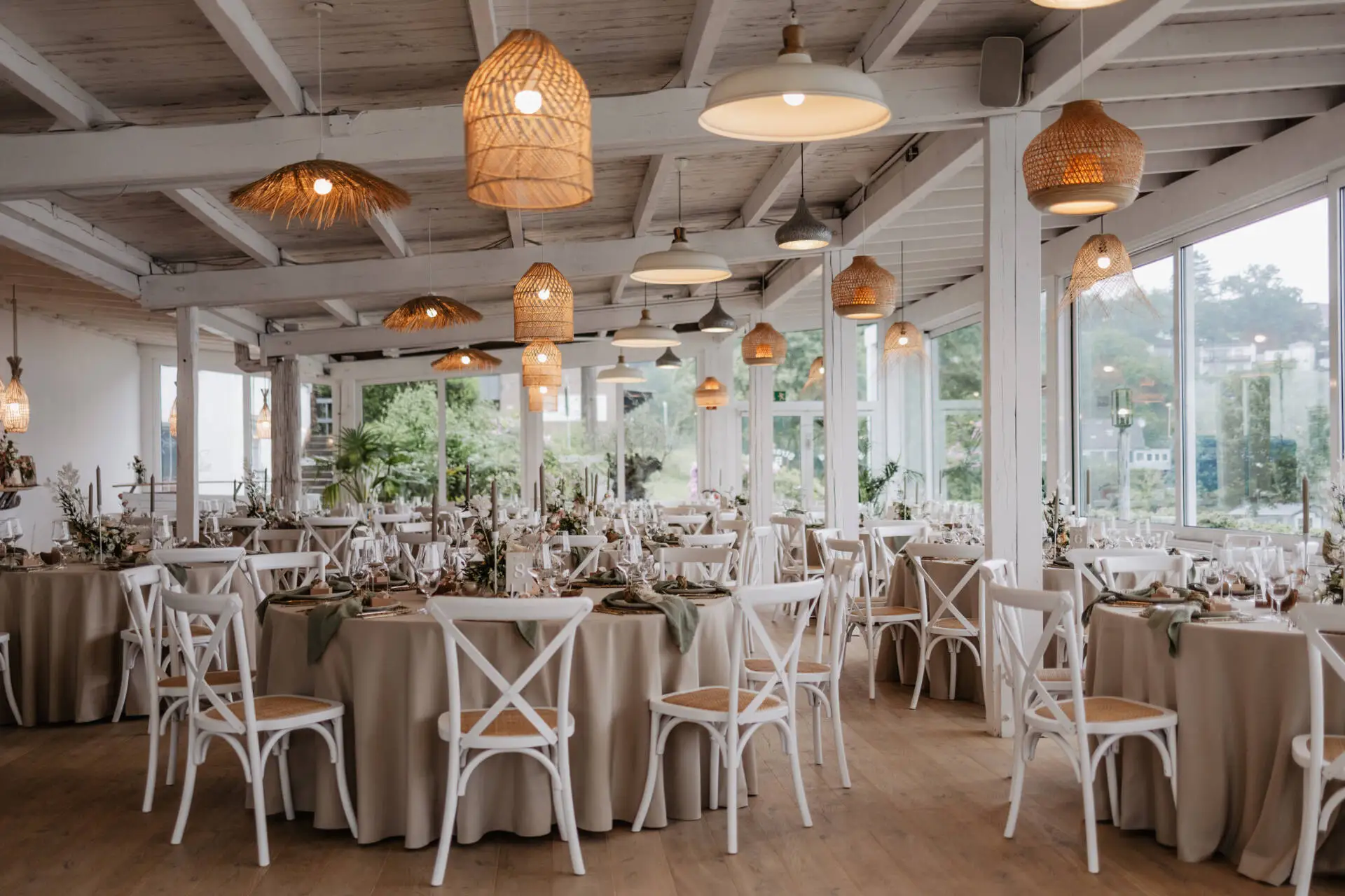 Elegantes Restaurant mit gedeckten Tischen und Naturbeleuchtung.