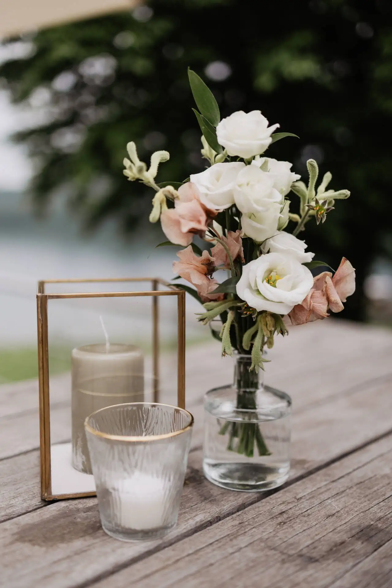 Blumenstrauß und Kerzen auf Holztisch