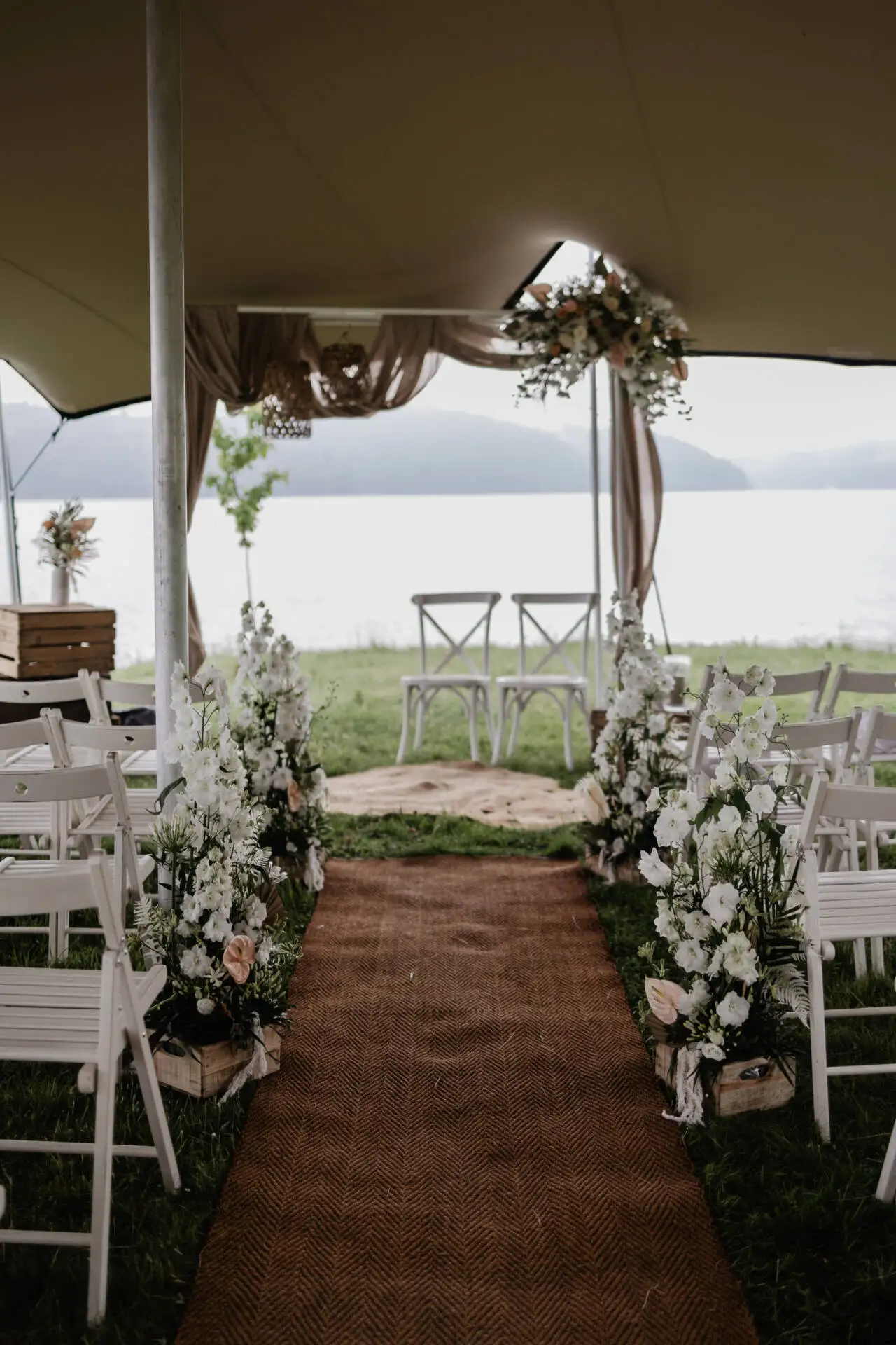 Hochzeitszeremonie am See unter Zelt.