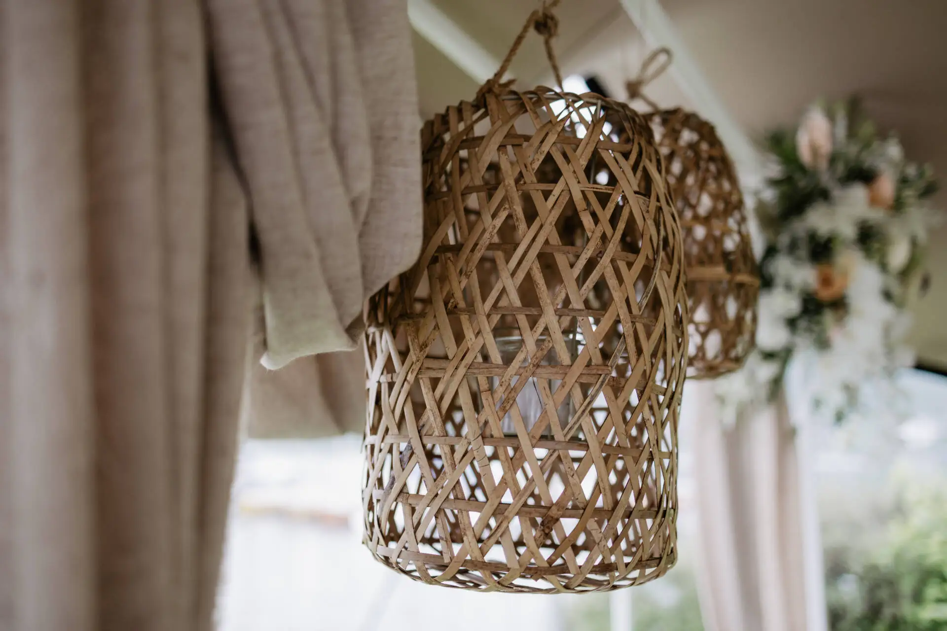 Verflochtene Bambuslaterne mit Blumen im Hintergrund