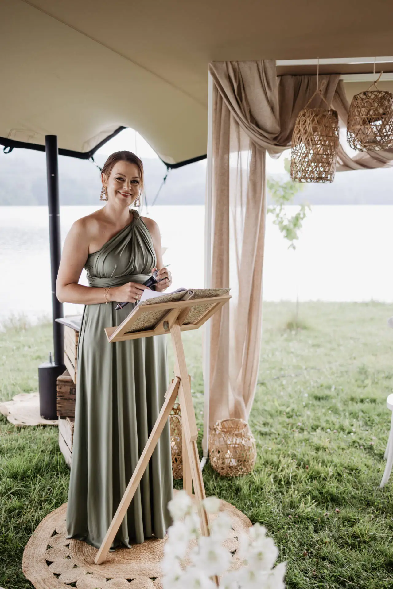 Frau in grünem Kleid bei Veranstaltung im Freien.
