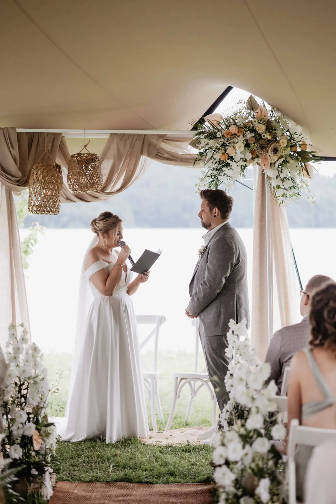 Braut und Bräutigam bei einer Trauung am Seeufer.